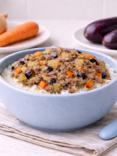 Beef eggplant rice bowl for babies served in a light blue baby bowl with diced beef, eggplant, carrot, and onion