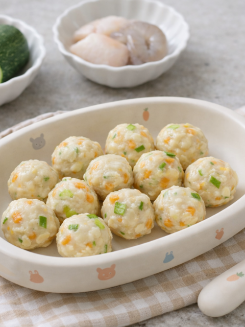 Homemade baby fish cakes made with white fish, shrimp, carrot, and zucchini served in a cute baby dish