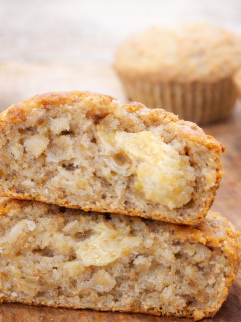 Soft and moist baby banana bread cut in half on a wooden board, showing its fluffy texture and natural banana chunks